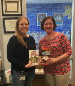 Matapeake Elementary School Reading Specialist Jenn Osborne receives new books for MES Guys Read participants from Friends of the Library President Kathie Smarick