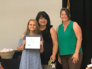 Kennard Elementary School Reading Pro recipient Kaisa Hickson, Kennard reading specialist Robin Blummer, and Friends of the Library Board of Directors member Beth Maier