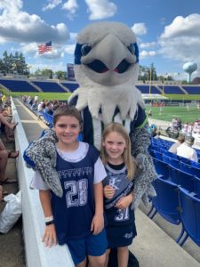 Summer Reading Program raffle winner Alexis Motto (7) and her brother Lucas (10) meet team mascot Hawkeye before the start of the Chesapeake Bayhawks game at Navy-Marine Corps Memorial Stadium in Annapolis.
